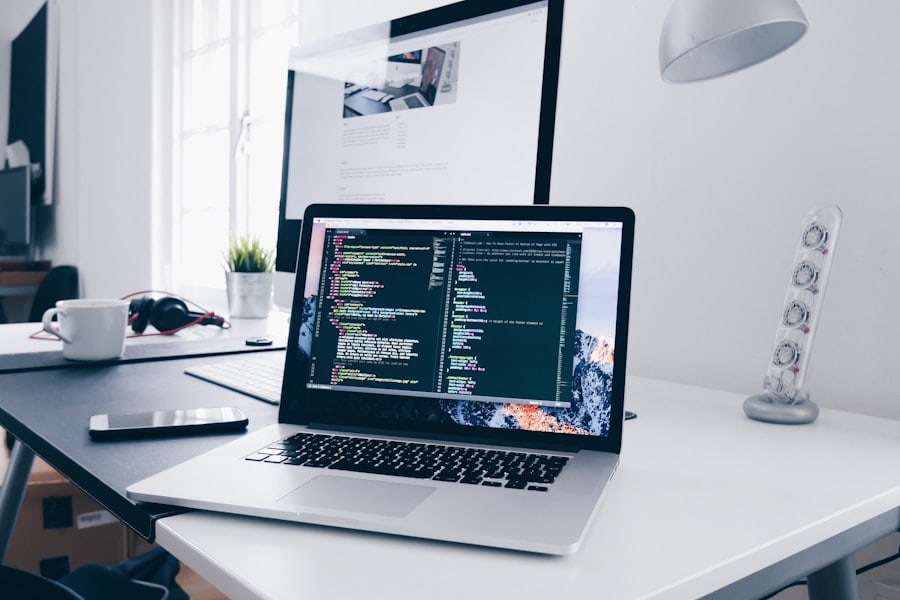 Laptop and monitor on a dim editorial desk